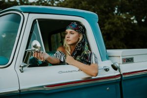 Young female Driver at the wheel of a classic pickup truck